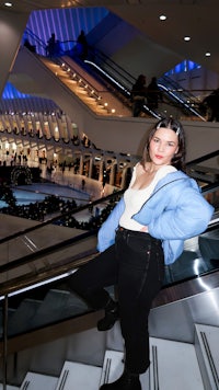 a woman standing on the stairs in a shopping mall