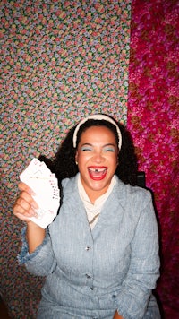a woman in a blue jacket holding a deck of cards