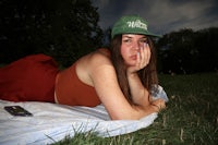 a woman laying on a blanket in the grass
