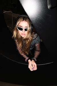 a young woman wearing sunglasses and a hat